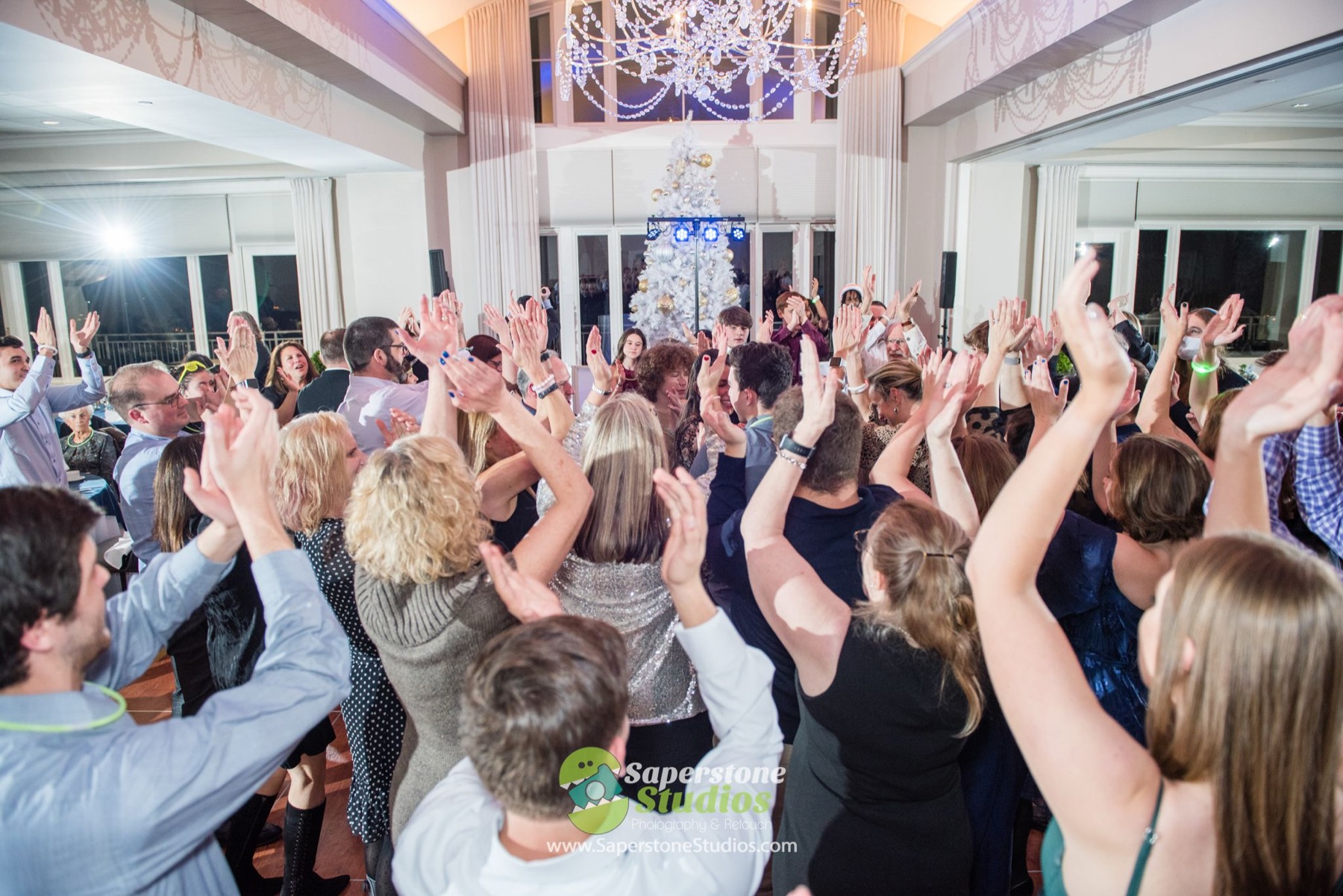 Guests with their hands up on a full dance floor