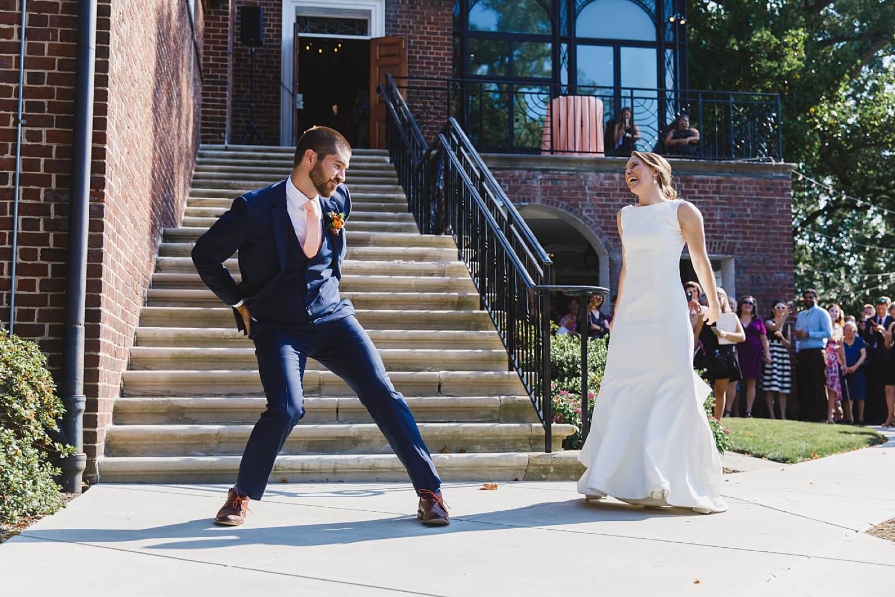 A couple dancing on the steps outside their reception
