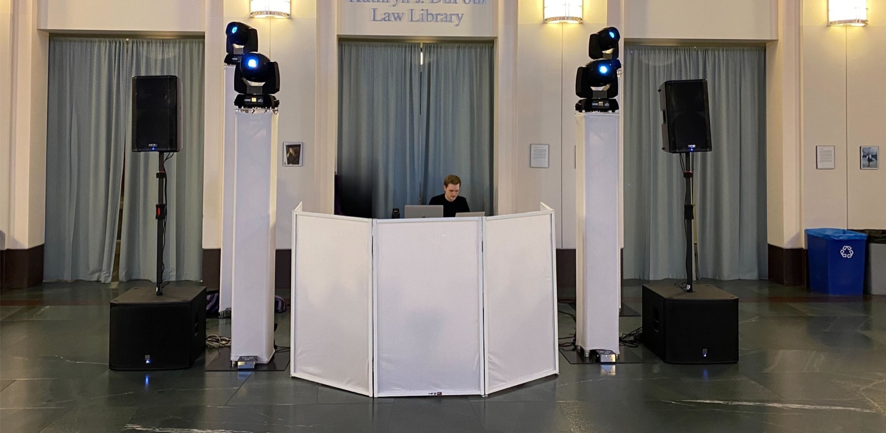 A DJ booth set up between speakers and lights